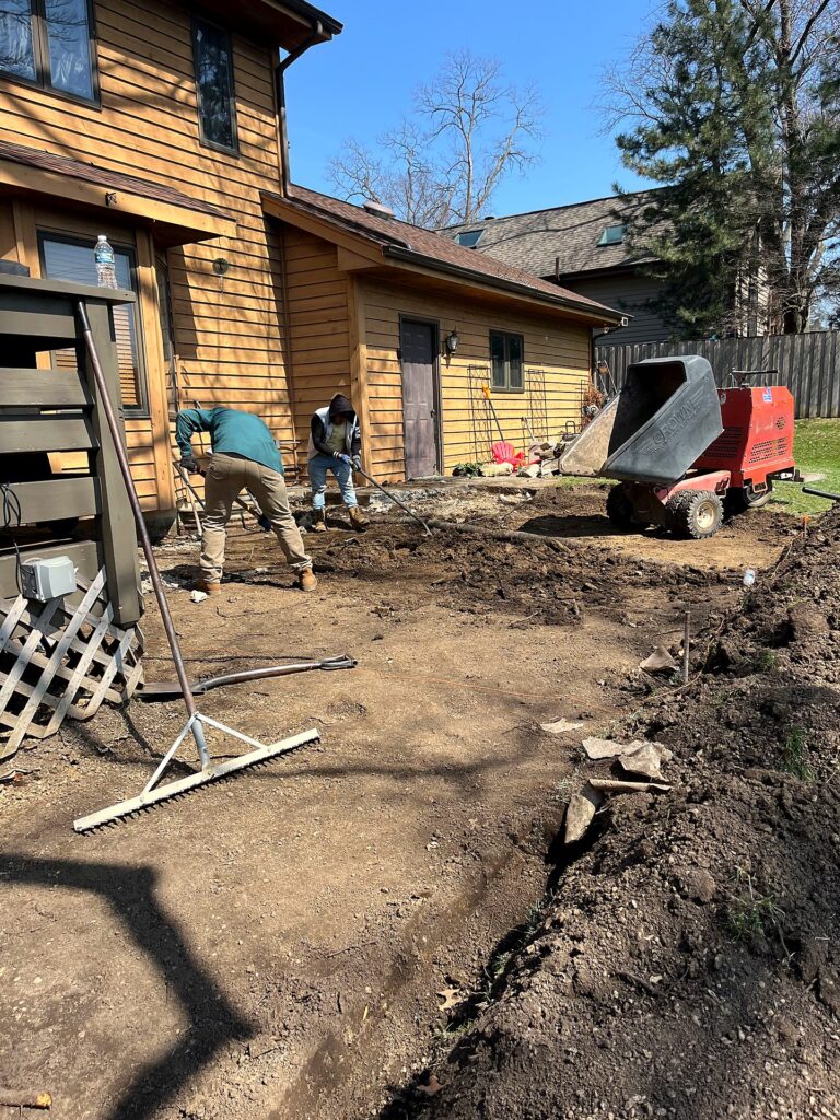 Patio area excavated to bare soil with string lines set for the base